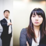 女性社員を指差す男