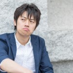 不満一杯の顔で口をへの字に曲げる男性